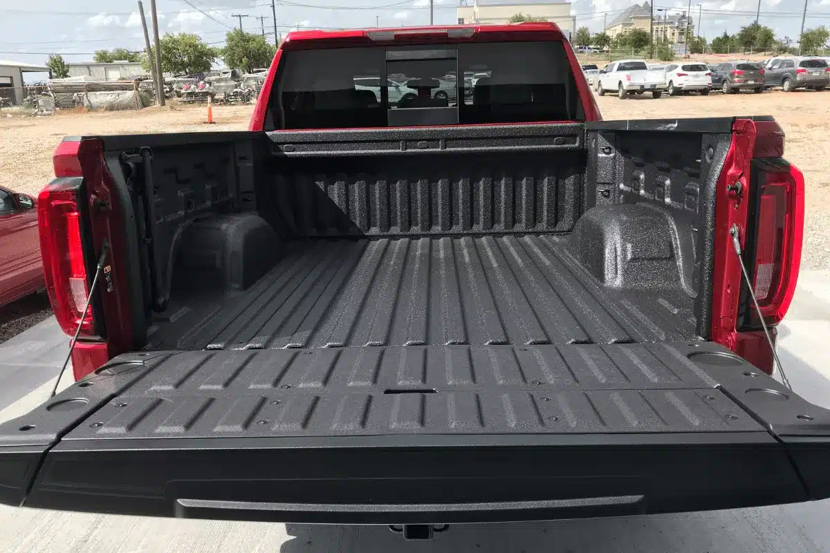 Rear view of a truck, highlighting the U.S. Linings spray-on bedliner, parked outside the application center.